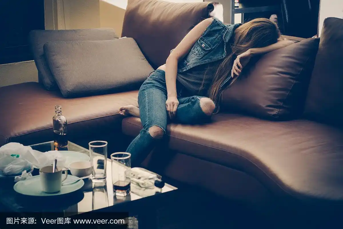 沙发上那个喝醉了的年轻女人.酗酒和吸毒成瘾会导致抑郁症
