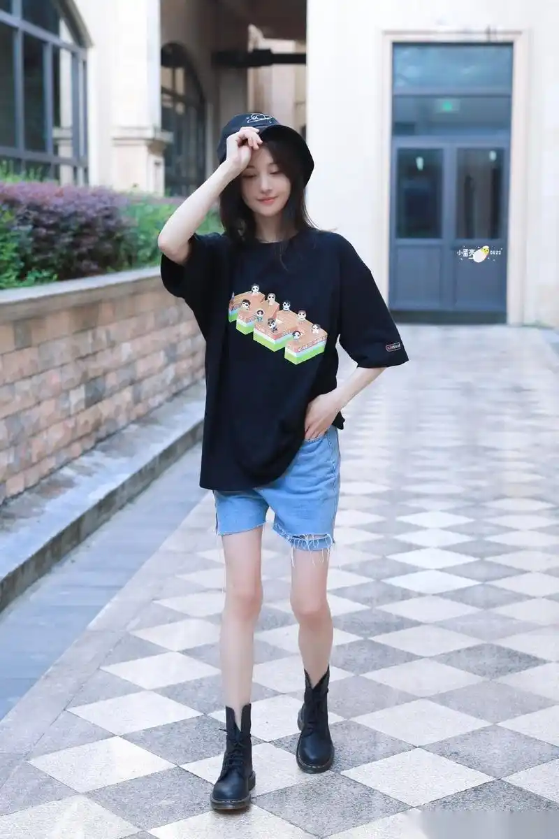 郑爽身穿黑t和牛仔短裤搭配马丁靴和渔夫帽出镜,笑容十分灵动俏皮,又