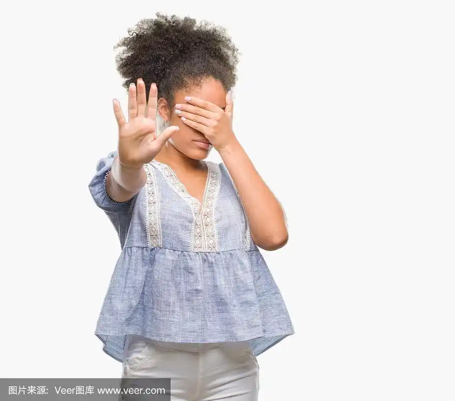 年轻的美国黑人妇女在孤立的背景用手遮住眼睛,做停止手势与悲伤和